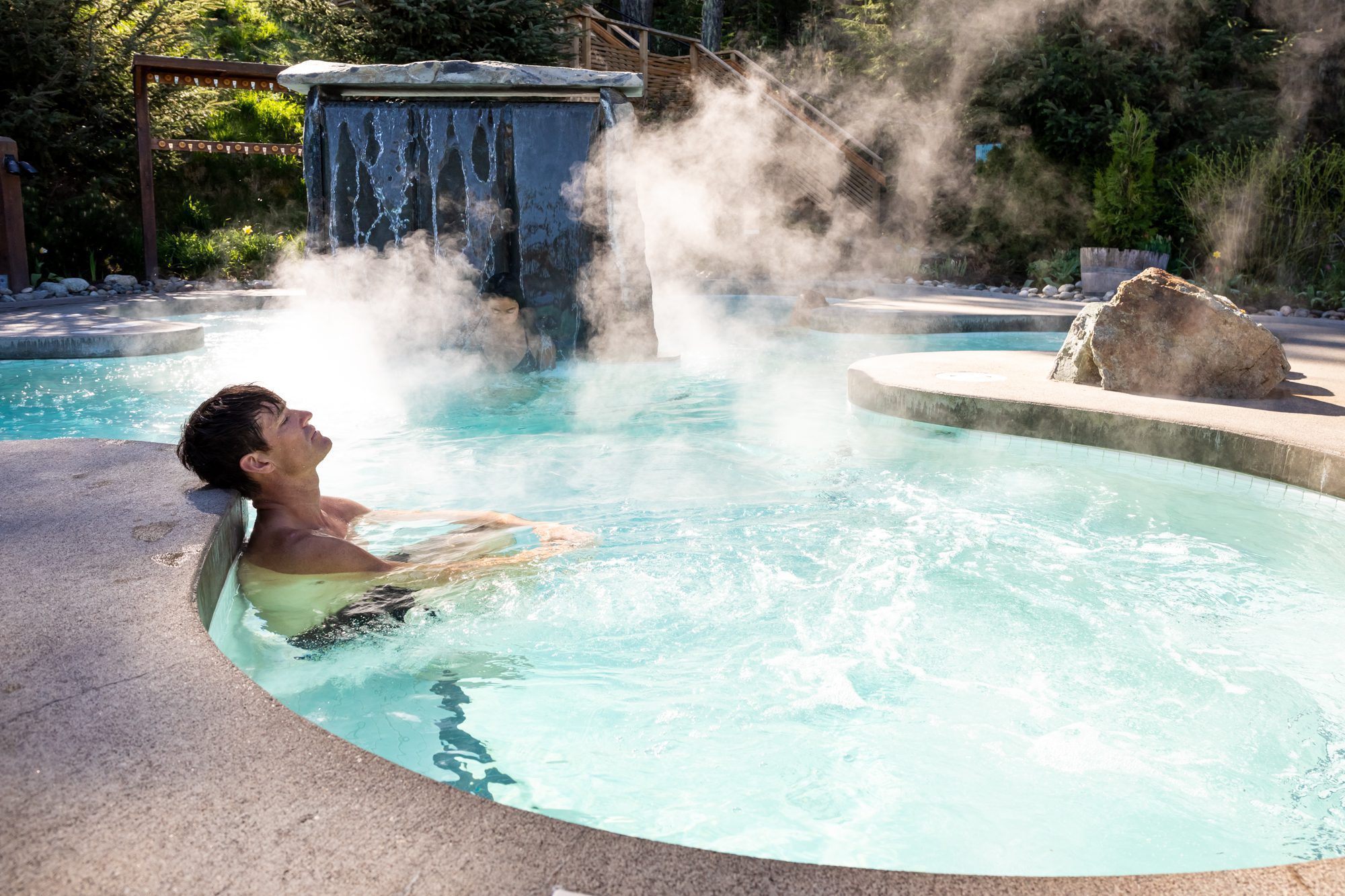 people relax in a steamy outdoor pool